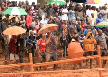 Fans cheering for the drivers as they brave the rain.