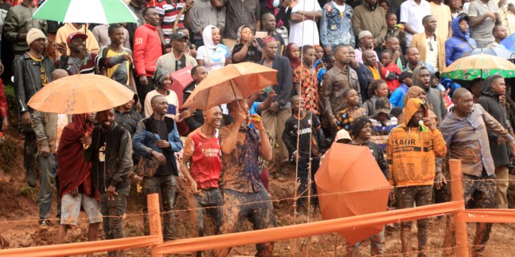 Fans cheering for the drivers as they brave the rain.